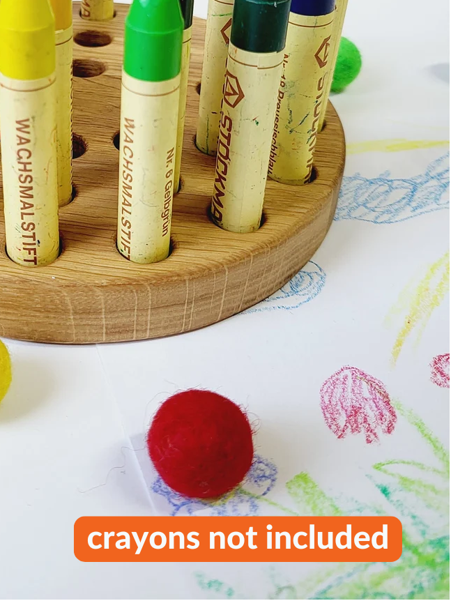 Wooden crayon holder with colorful crayons on a white background