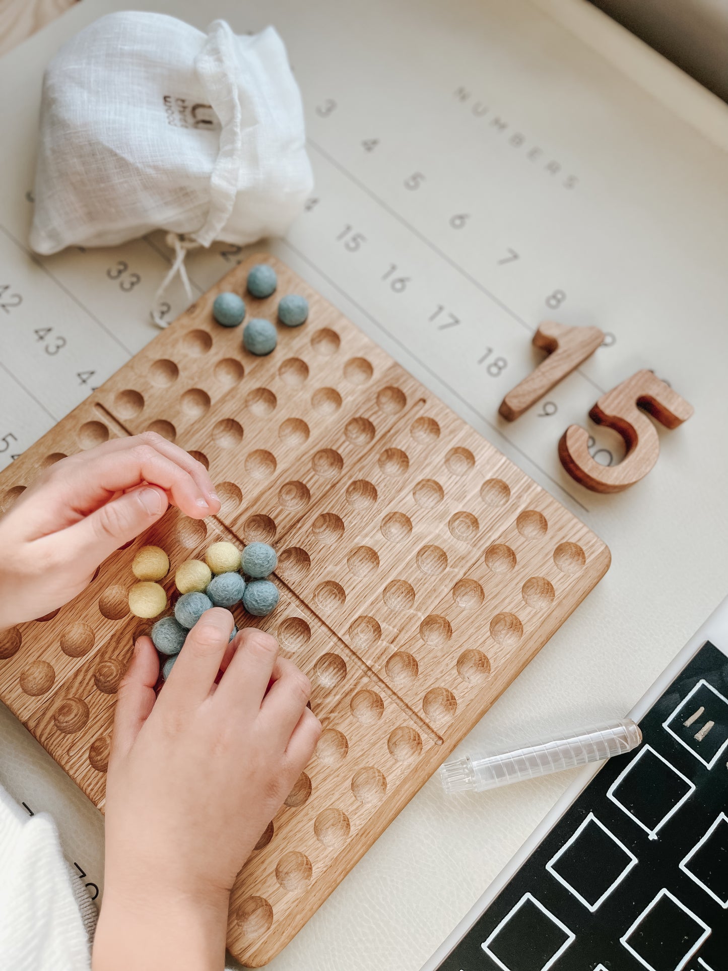 Montessori hundred board with numbers 1-100 and felt balls